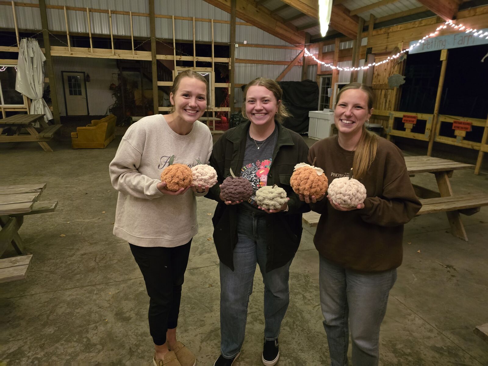 Guests showing off painted pumpkins at a farm event